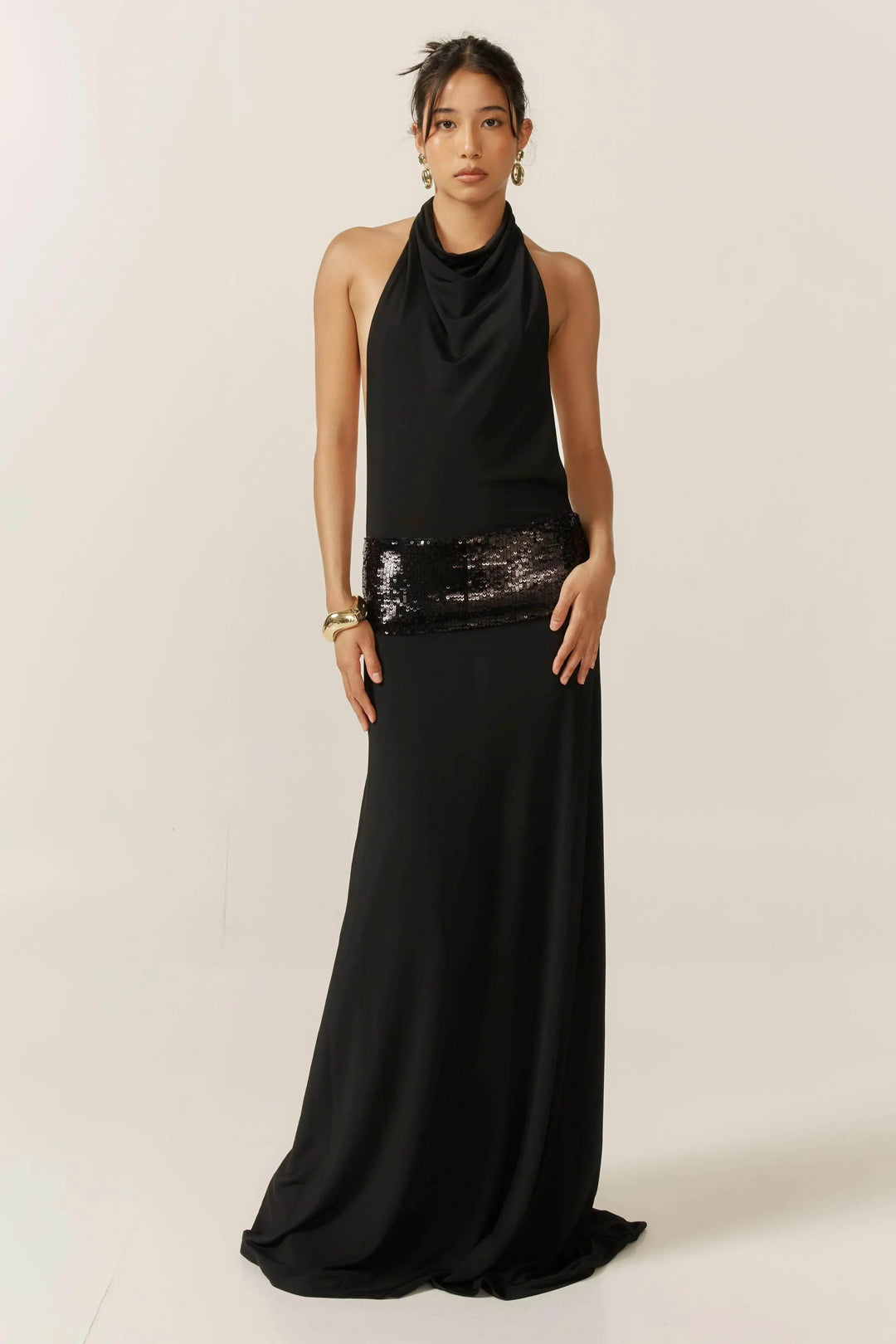 Robe longue noire femme avec dos nu et sequins, confectionnée en tissu léger, parfaite pour des occasions spéciales.