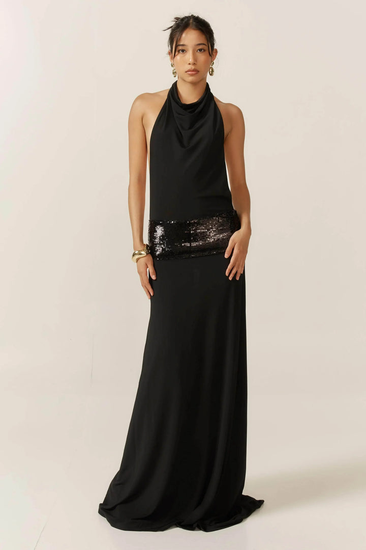 Robe longue noire femme avec dos nu et sequins, confectionnée en tissu léger, parfaite pour des occasions spéciales.