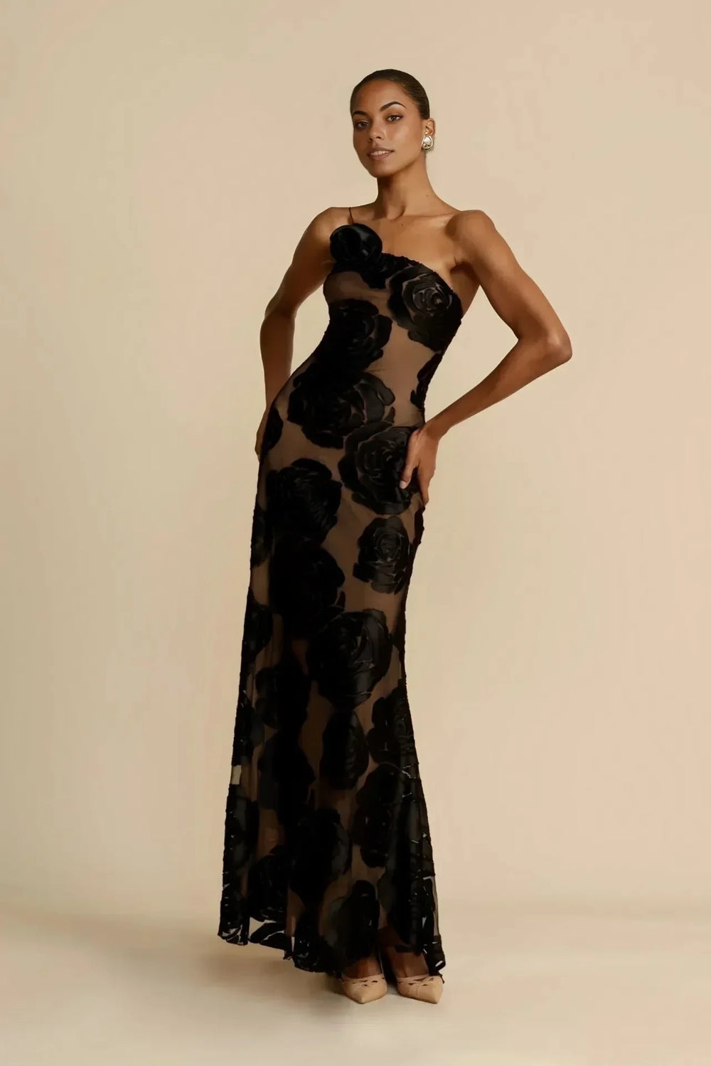Robe longue noire avec motifs floraux transparents, idéale pour les soirées d'été, en tissu léger et fluide.