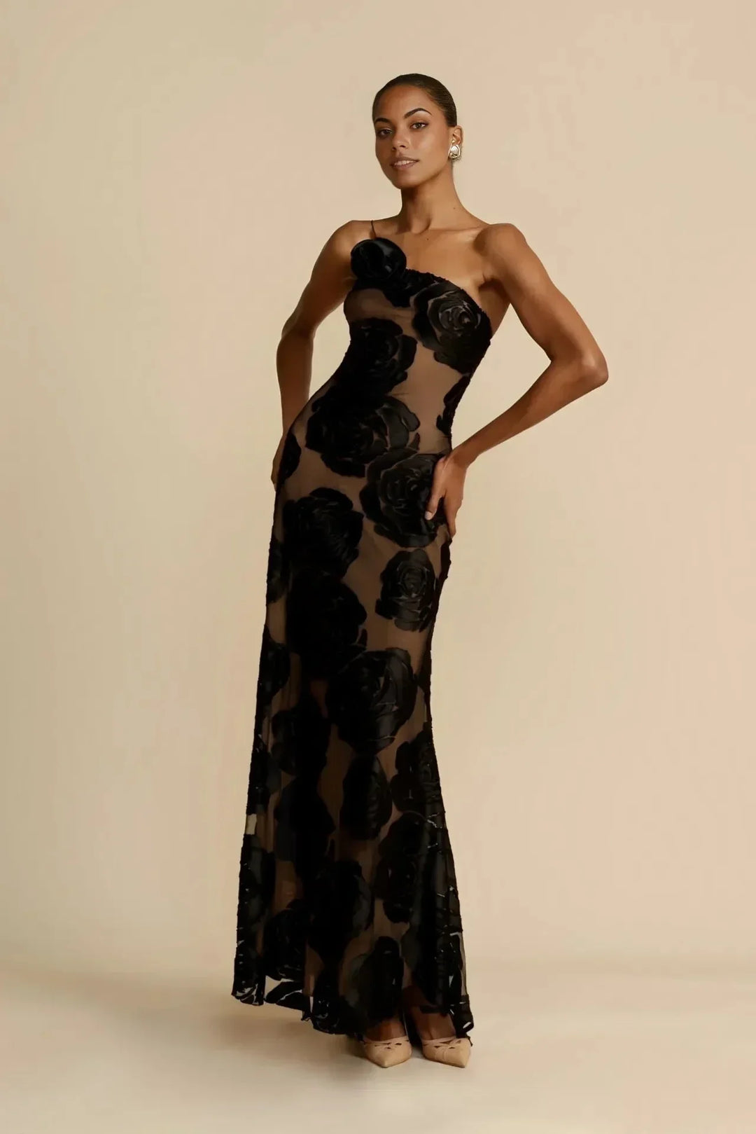 Robe longue noire avec motifs floraux transparents, idéale pour les soirées d'été, en tissu léger et fluide.