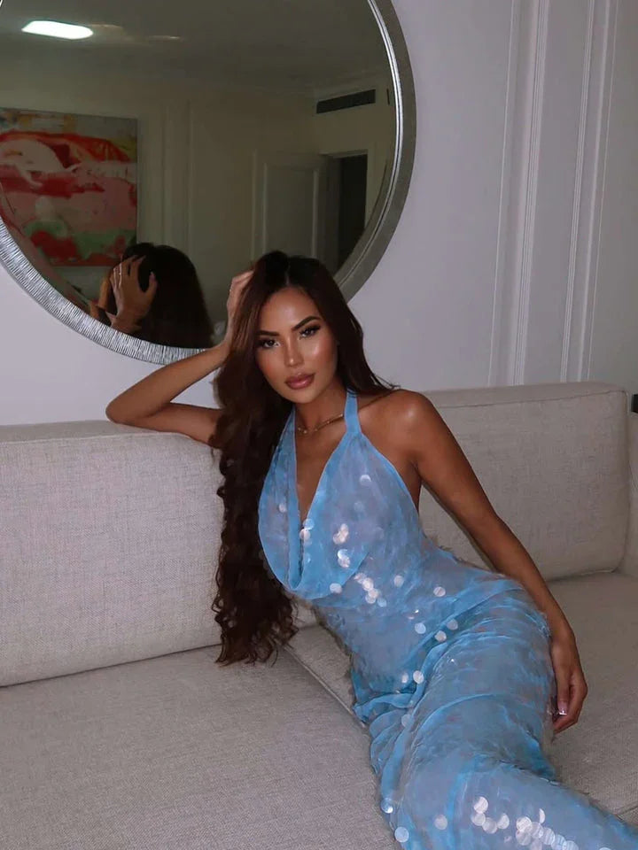 Robe longue pailletée bleu ciel avec décolleté en V, tissu léger et brillant, parfaite pour les occasions spéciales.