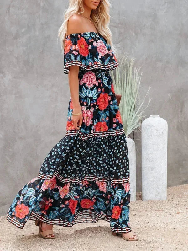 Robe longue à épaules dénudées, en tissu léger, avec motifs floraux colorés et design fluide, idéale pour l'été.