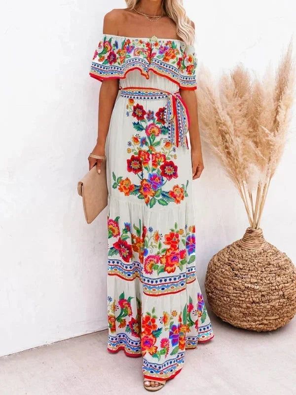 Robe longue à épaules dénudées, en coton léger, avec motifs floraux colorés sur fond pastel pour un look élégant.