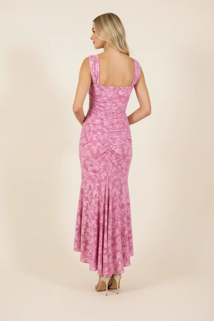 Robe longue rose avec drapés et motifs fleuris, en tissu léger et confortable, parfaite pour des occasions estivales.
