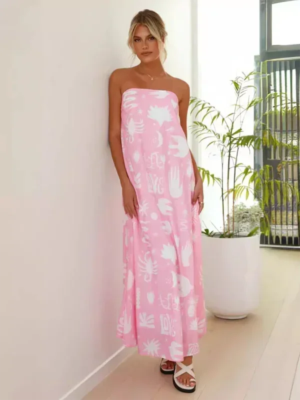 Robe longue sans bretelles en rose, légère avec motifs estivaux, idéale pour les journées chaudes et décontractées.