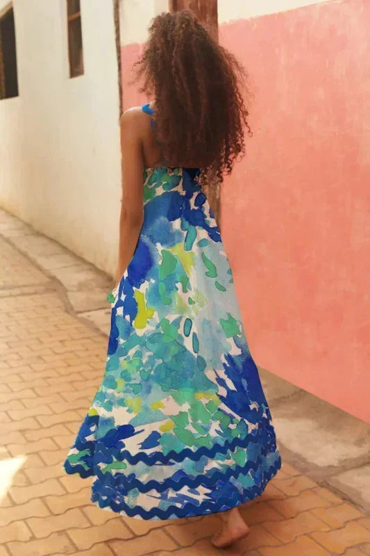 Robe longue femme sans manches en tissu léger, avec un bord ondulé et un design fluide, idéale pour les journées chaudes.