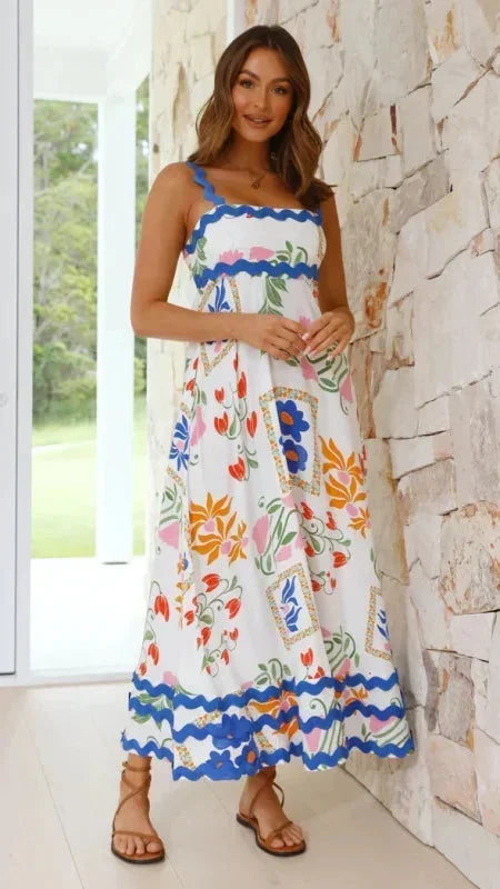Robe longue femme sans manches en tissu léger, avec un bord ondulé, motifs blancs et bleus. Idéale pour les journées d'été.