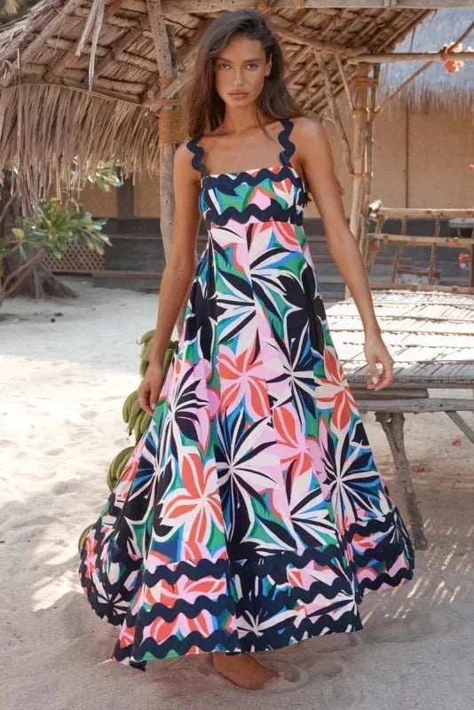 Robe longue sans manches en bleu foncé, avec un bord ondulé élégant et confectionnée dans un tissu léger et fluide.