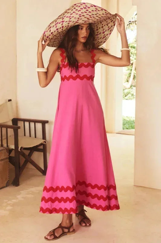 Robe longue rose sans manches, en coton léger, avec un bord ondulé pour un style fluide et féminin.