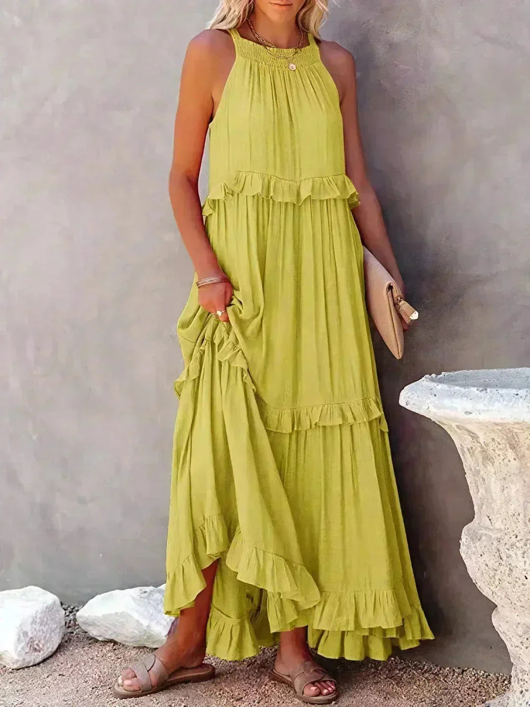 Robe longue jaune sans manches avec volants superposés en tissu léger, offrant une coupe fluide et agréable au corps.
