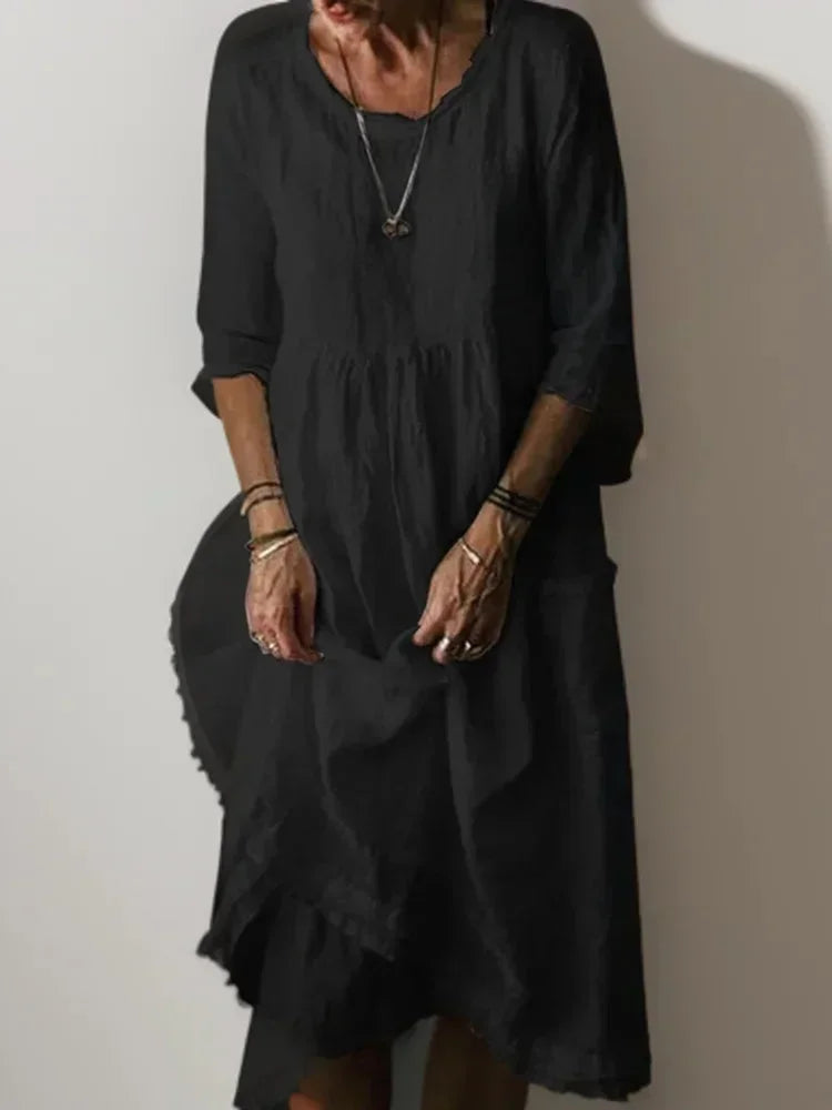 Robe longue noire à volants, col en V, manches 3/4, en tissu fluide pour un confort et un style décontracté.