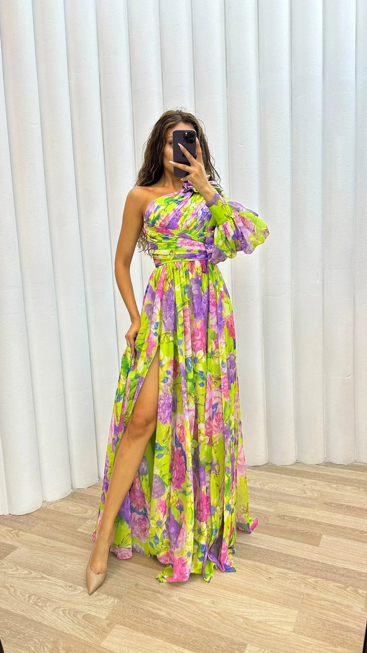 Robe longue florale à une épaule, avec une fente fluide, idéale pour des soirées d'été en tissu léger et aérien.
