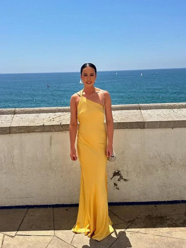 Robe longue satinée à bretelles fines avec dos ouvert, parfaite pour des occasions spéciales, en matière douce et fluide.