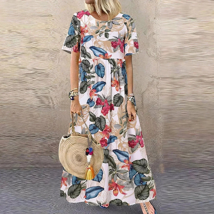 Robe longue blanche à volants, motif botanique, manches courtes en tissu léger pour une allure estivale et fraîche.