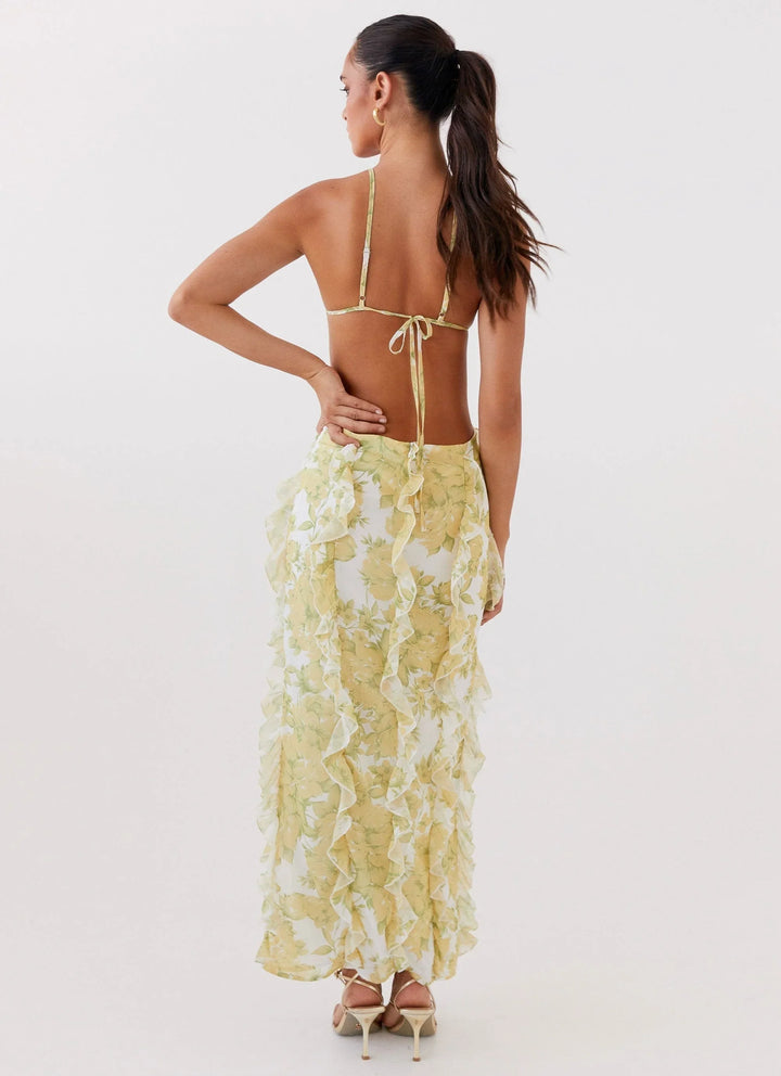 Robe longue à volants en coton, avec un motif floral jaune éclatant, idéale pour les journées ensoleillées.