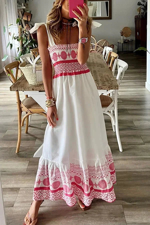 Robe longue blanche légère avec motifs tribaux roses, encolure carrée, sans manches, idéale pour l'été à la plage.