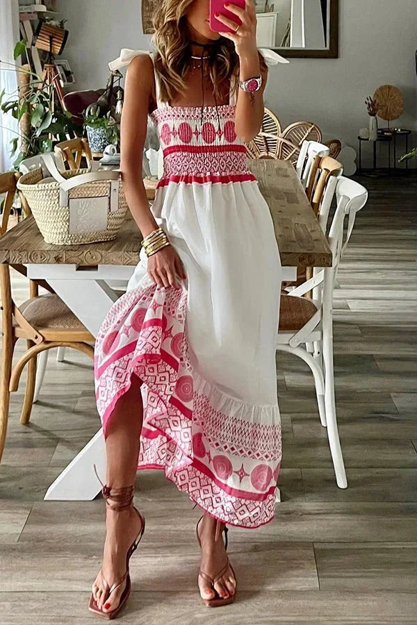 Robe longue blanche à motifs tribaux roses, encolure carrée sans manches, idéale pour l'été à la plage, en tissu léger.