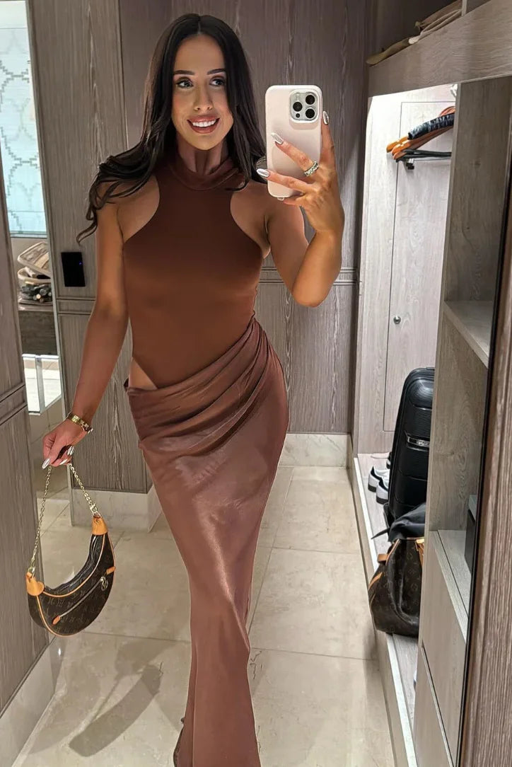 Robe longue en tissu fluide avec col halter, découpes latérales et drapé pour un look élégant.
