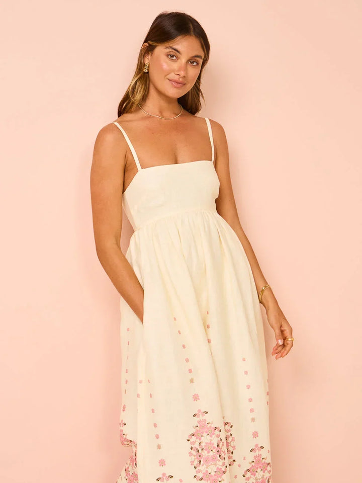 Robe longue crème avec broderie florale, bretelles fines, en coton léger, idéale pour l'été.