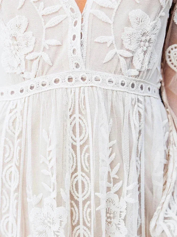 Robe longue en dentelle transparente, manches longues, col en V, idéale pour une soirée élégante. Détails raffinés et fluidité.