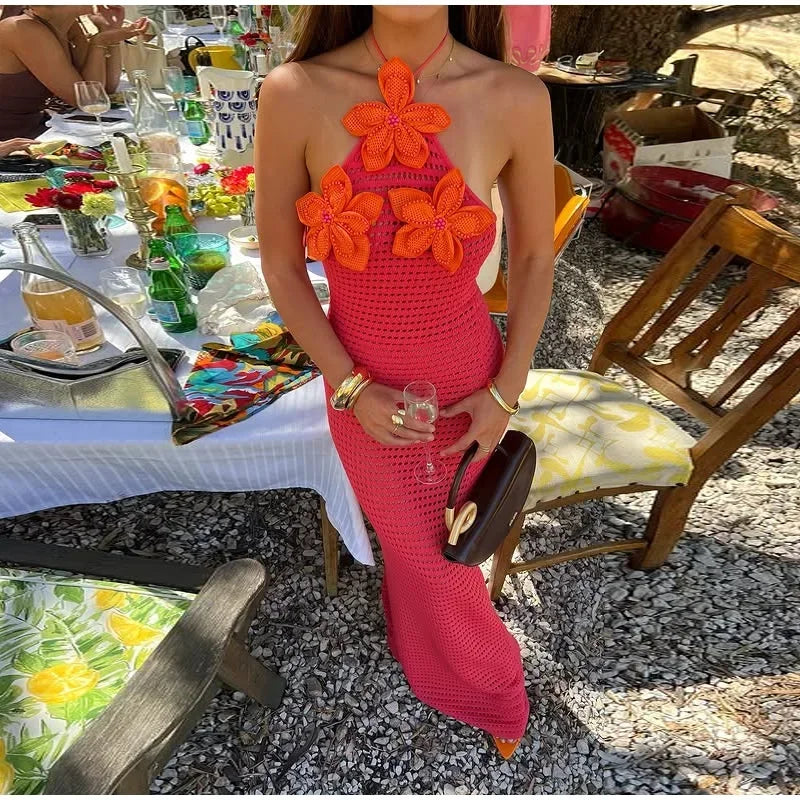 Robe maxi en crochet rose ornée de fleurs oranges, légère et confortable, idéale pour les journées ensoleillées.