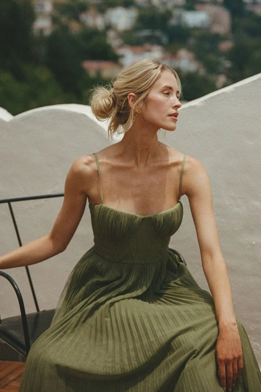 Robe maxi femme verte plissée en tissu léger, décorée de plis élégants et avec des bretelles fines pour un look décontracté.