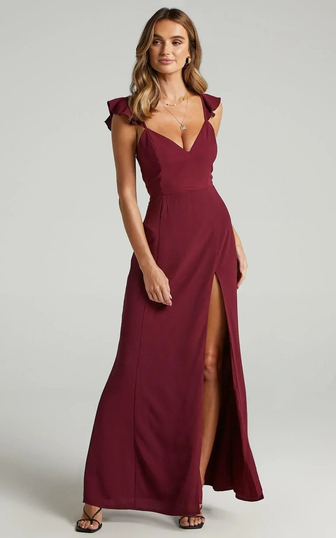 Robe longue fendue avec manches à détails, en tissu léger, parfaite pour les soirées. Idéale pour un look élégant.