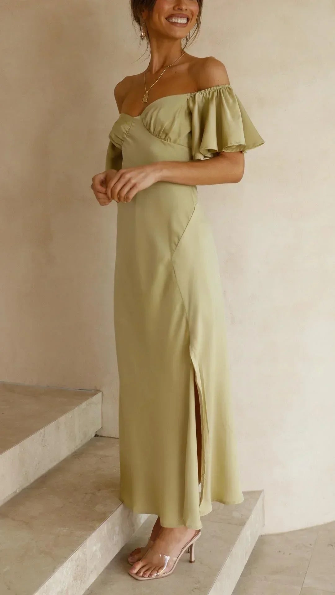 Robe longue fluide, épaules dénudées, fente sur le côté, idéale pour les soirées d'été, confectionnée en tissu léger.