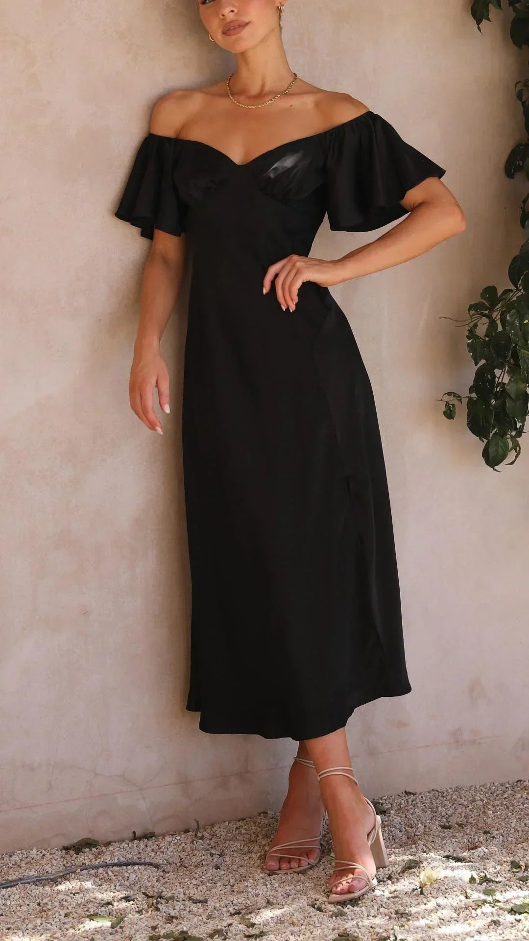 Robe longue fluide avec décolleté épaule dénudée et fente, parfaite pour les soirées d'été. Matière légère et élégante.