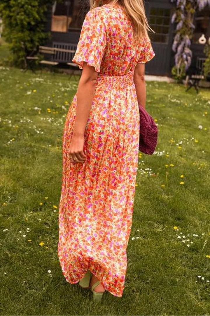 Robe longue fleurie à manches courtes, col en V, en tissu fluide parfait pour l'été. Imprimé floral coloré.