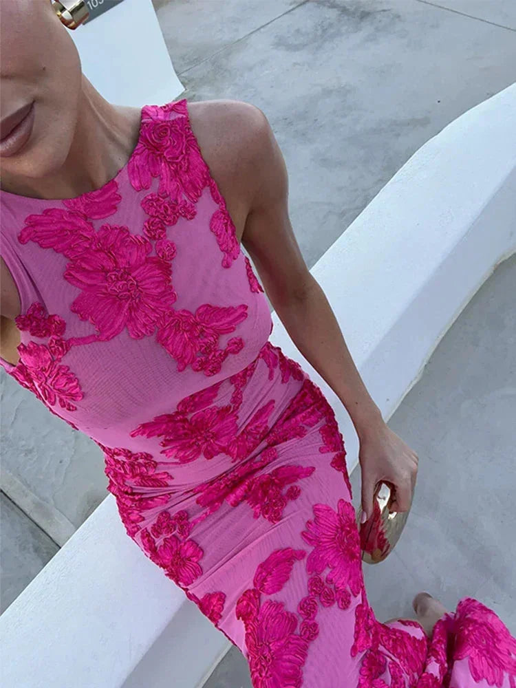 Robe longue fleurie rose sans manches, en tissu léger, offrant un style délicat et fluide pour les soirées d'été.