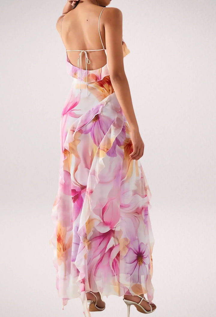 Robe longue fleurie rose sans manches avec volants, en tissu léger, idéale pour les journées estivales ensoleillées.