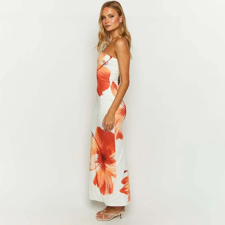 Robe longue fleurie sans bretelles, blanche et orange, en tissu léger pour l'été, parfaite pour une tenue décontractée.