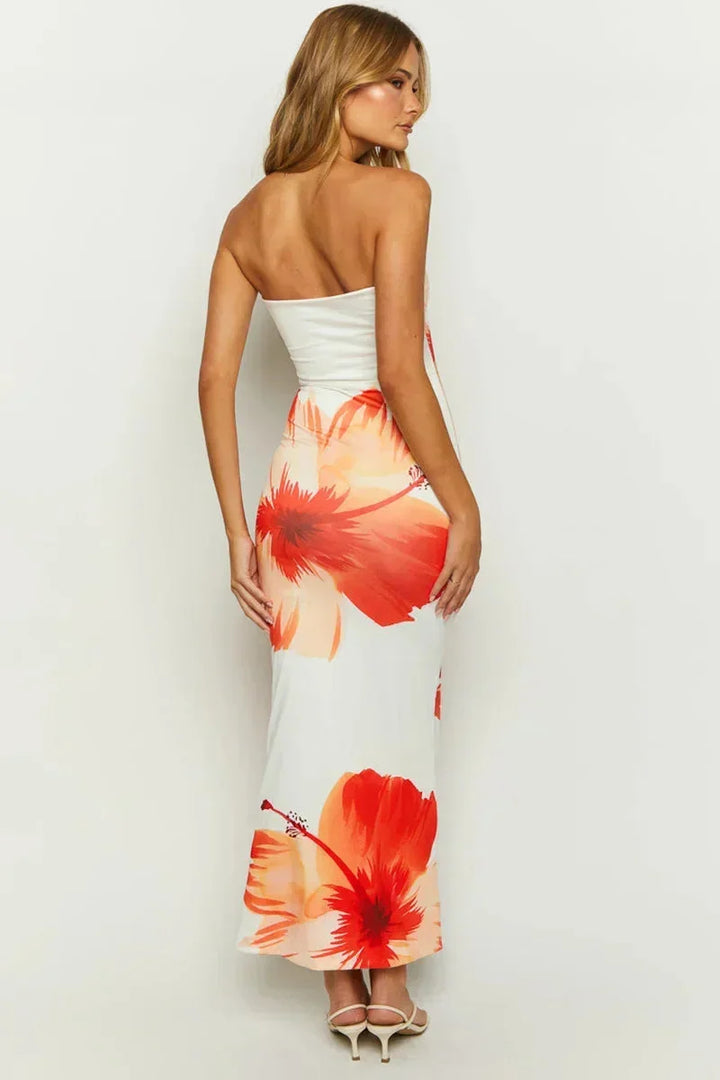 Robe longue fleurie sans bretelles blanche et orange, en tissu léger idéal pour l'été, avec un motif floral coloré.
