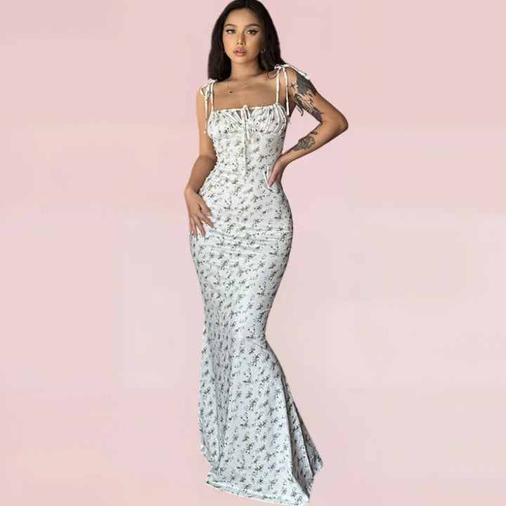 Robe longue fleurie sans manches, bretelles ajustables, en tissu léger idéal pour les journées d'été. Design floral coloré.