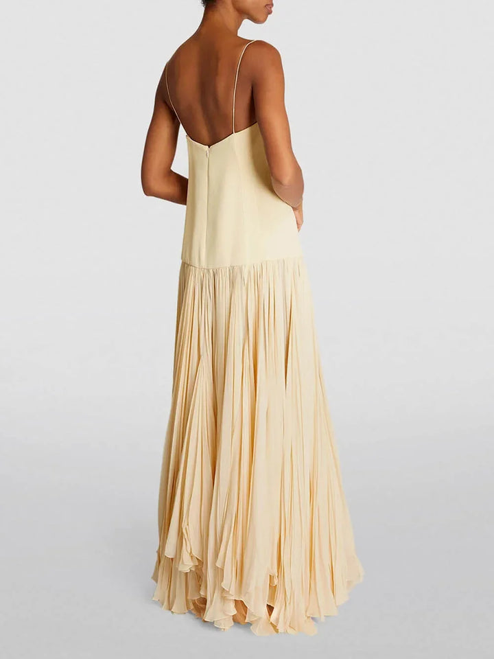 Robe longue ivoire sans manches, plissée, à bretelles fines, idéale pour les soirées d'été. Matière légère et fluide.