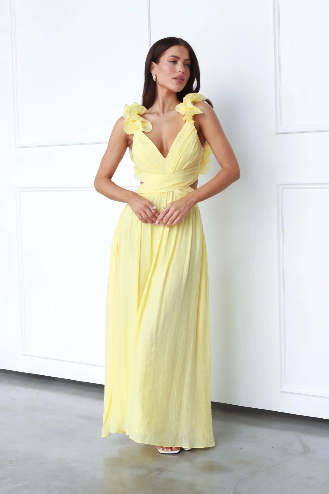 Robe longue jaune sans manches, col en V, tissu fluide et léger avec accents floraux, idéale pour l'été.