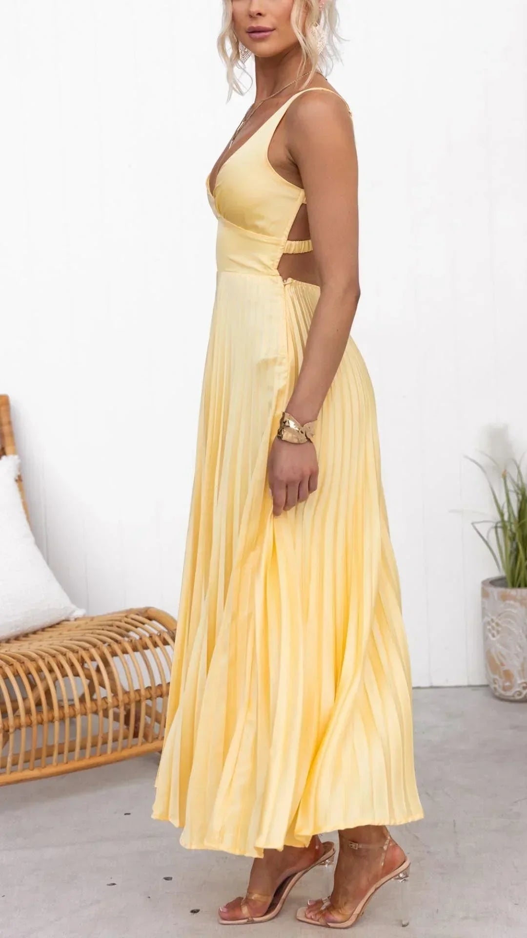 Robe longue jaune plissée sans manches avec col en V, en tissu léger, idéale pour les journées d'été.