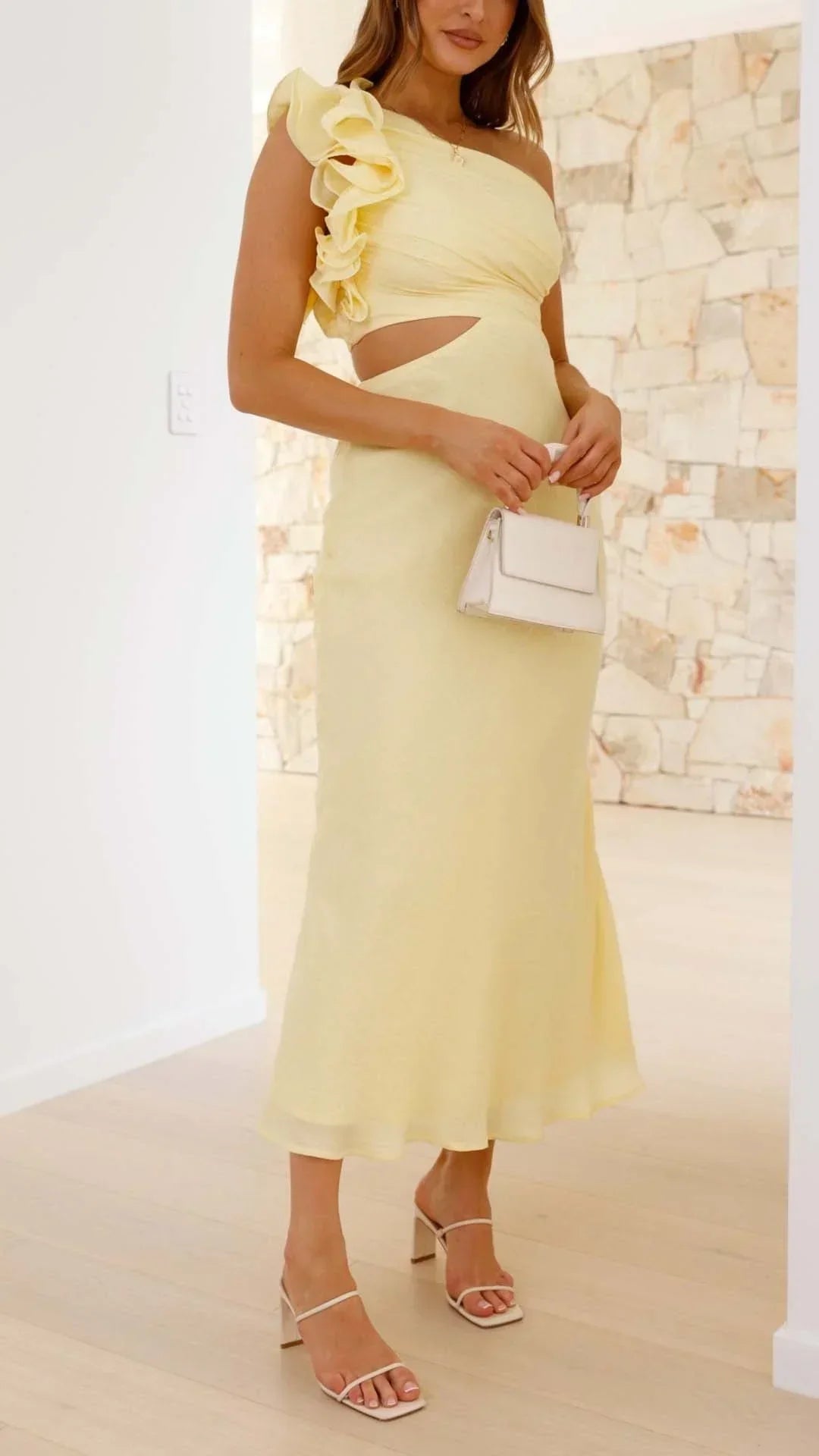 Robe longue jaune à une épaule, en tissu léger, avec découpes modernes et fluide, parfaite pour les soirées estivales.