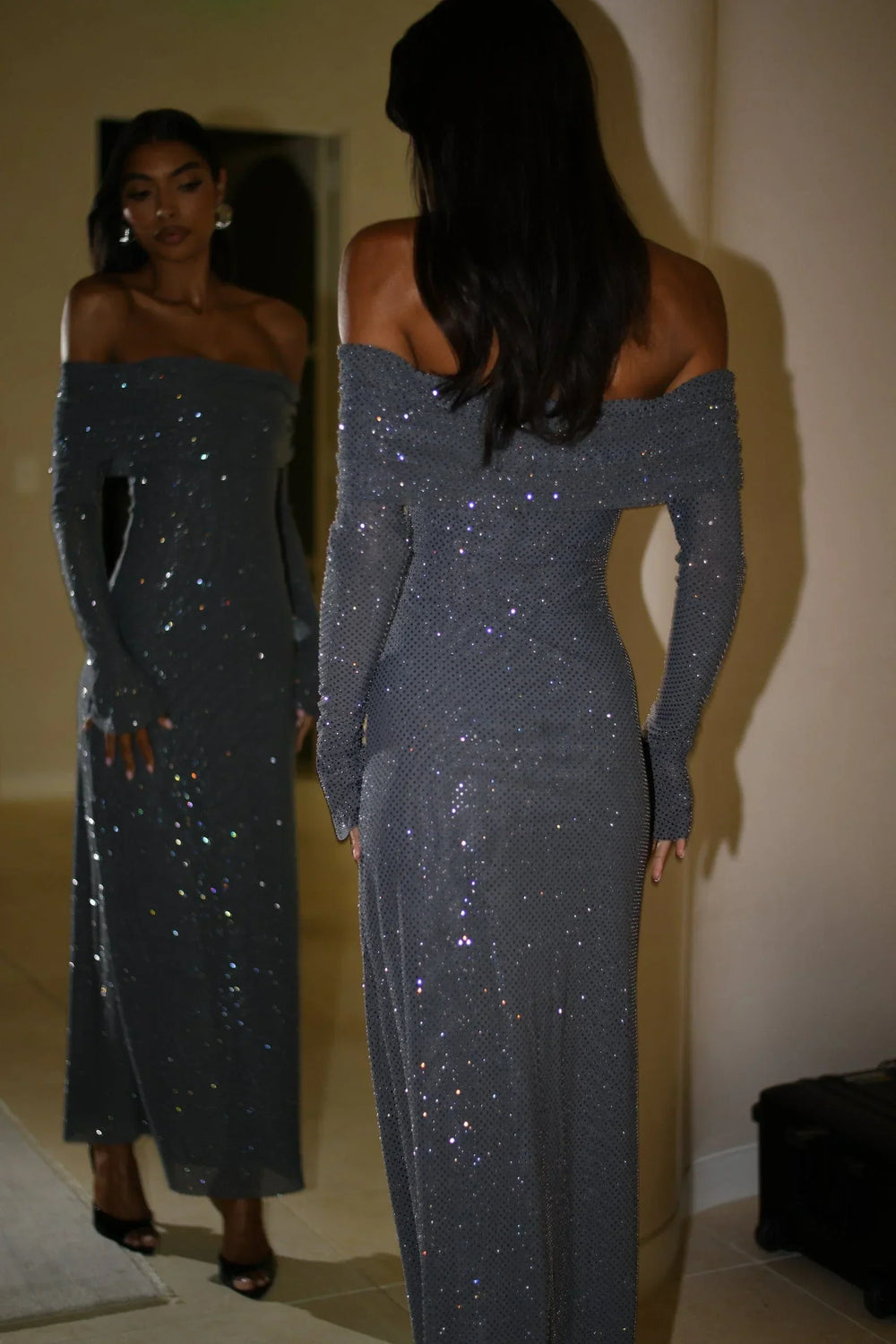 Robe longue longue en tissu scintillant, épaules dénudées, manches longues avec détails brillants pour un look élégant.