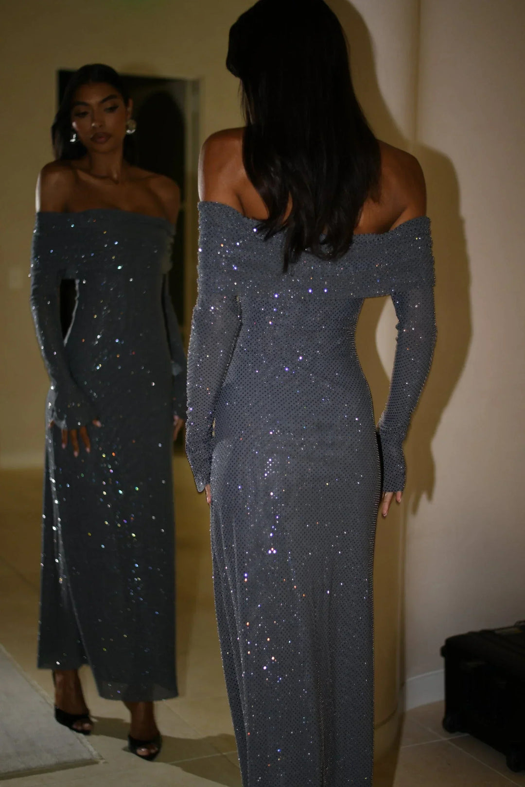 Robe longue longue en tissu scintillant, épaules dénudées, manches longues avec détails brillants pour un look élégant.