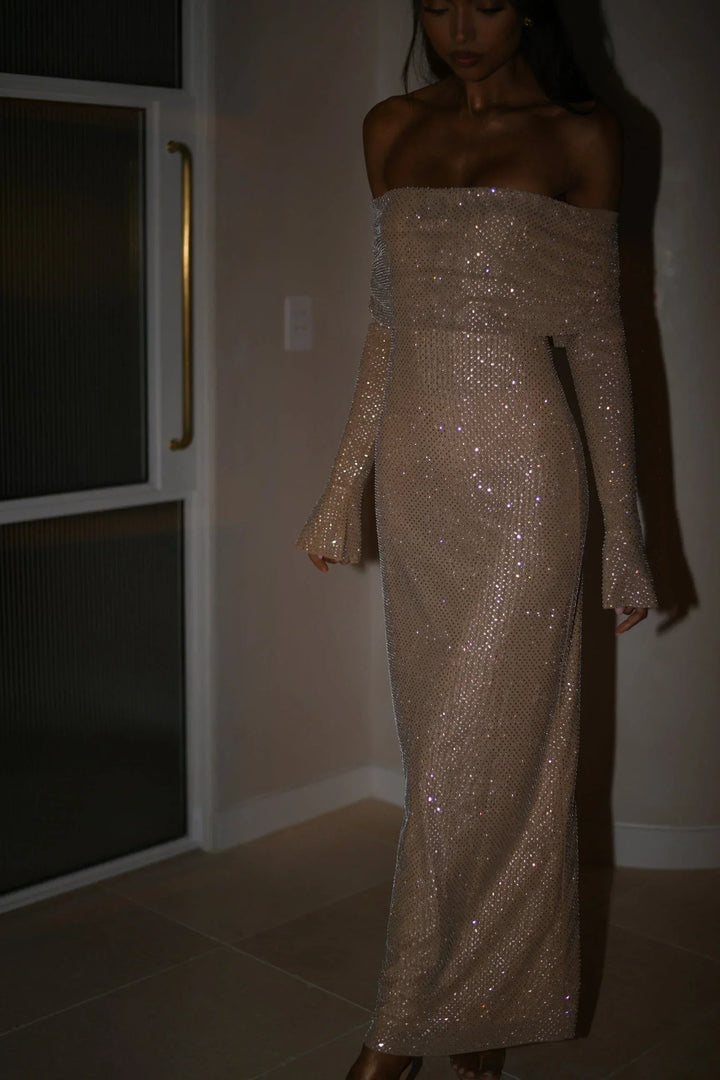 Robe longue longue en tissu scintillant, épaules dénudées et manches longues avec détails brillants pour un look élégant.