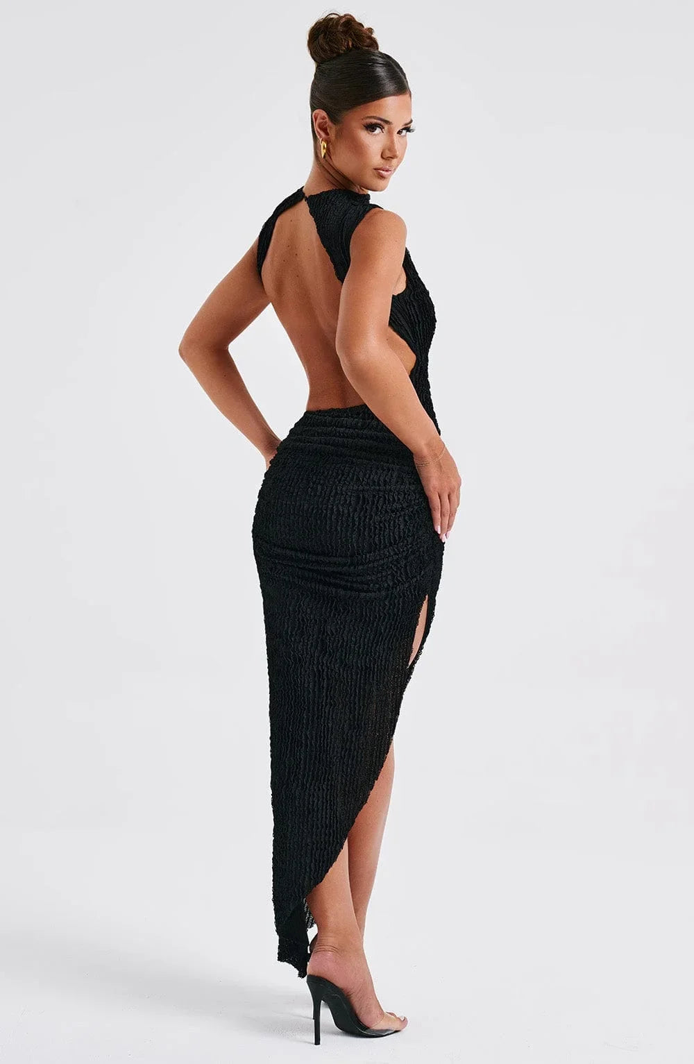 Robe longue noire sans manches, coupe ajustée, fente latérale, en tissu texturé pour une soirée élégante.