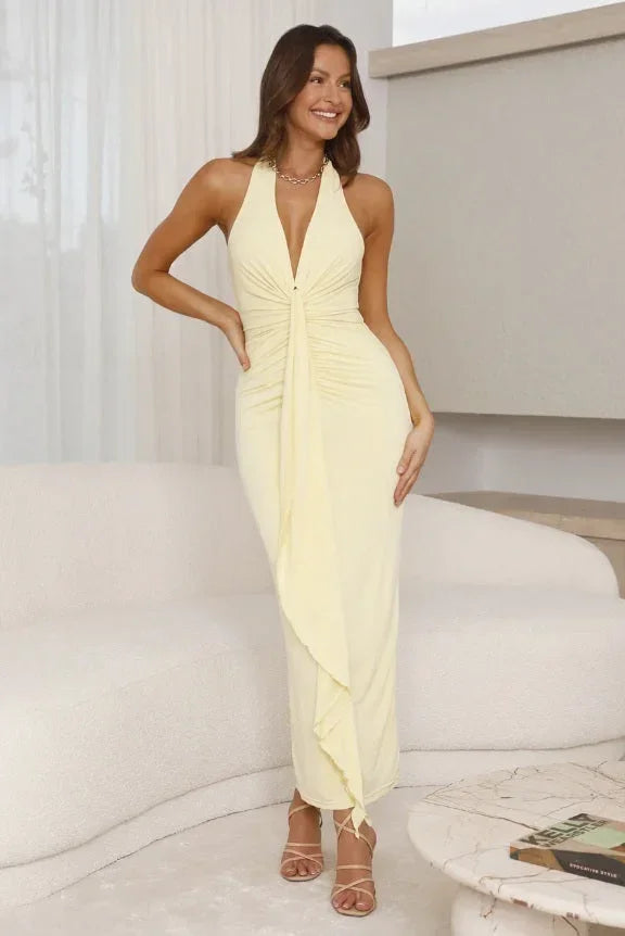 Robe longue à plis jaune citron, col licou, tissu fluide, parfaite pour les soirées d'été. Design élégant et léger.