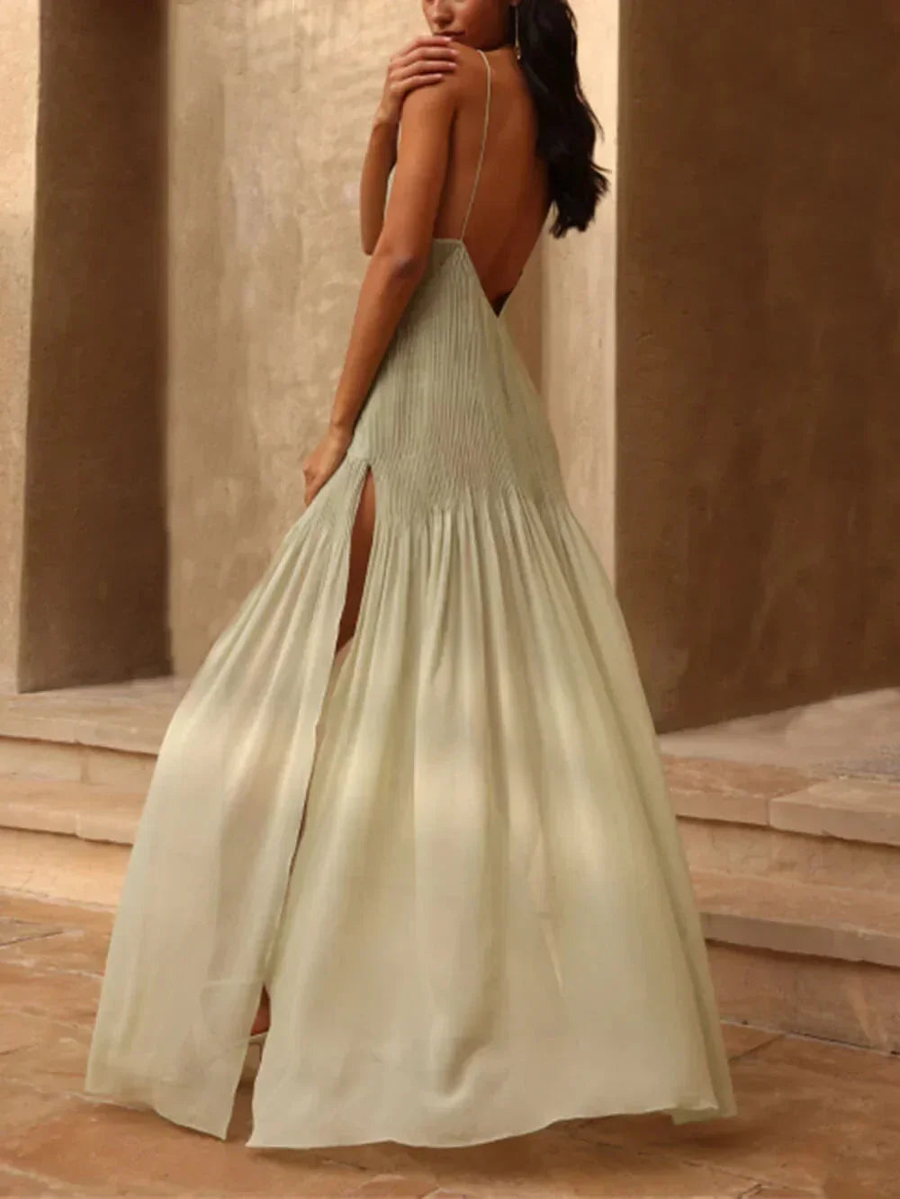 Robe longue plissée vert clair, sans manches, avec fente élégante, parfait pour les soirées. Matière fluide et agréable.
