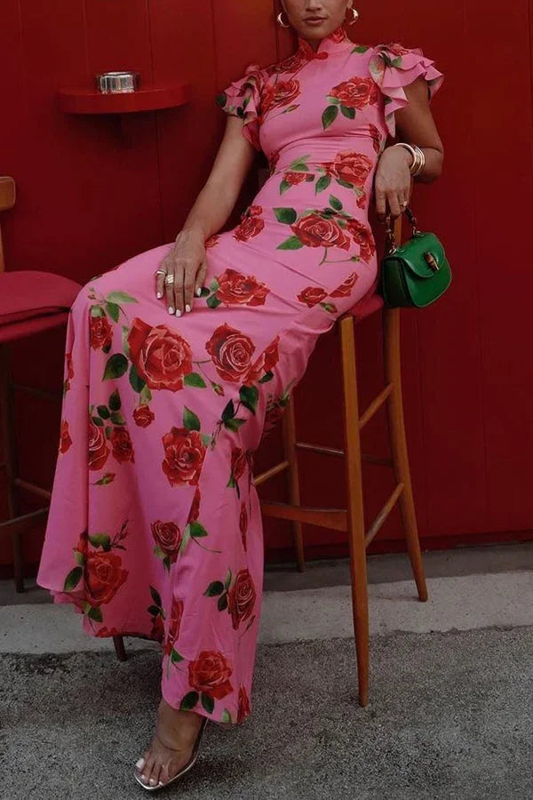 Robe longue rose à motifs floraux, manches volantées et col haut, en tissu léger pour un confort optimal.