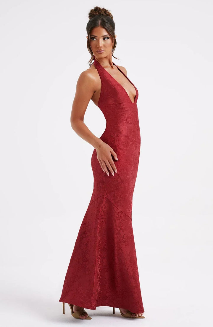 Robe longue rouge en tissu texturé, col licou avec nœud, idéale pour les soirées élégantes.