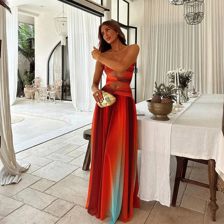 Robe longue sans bretelles rouge et orange à motifs blocs, confectionnée en tissu léger, idéale pour les soirées d'été.