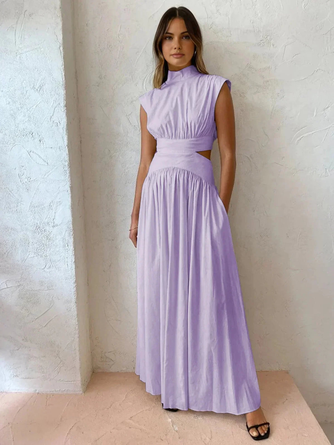 Robe longue sans manches, col montant, découpes stylées, tissu léger, parfaite pour une soirée estivale.