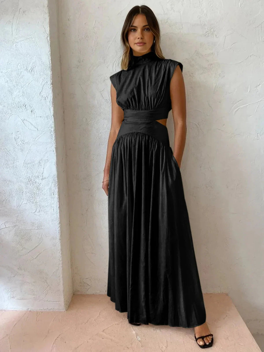 Robe longue sans manches en tissu léger, col montant avec découpes élégantes, idéale pour des soirées d'été.